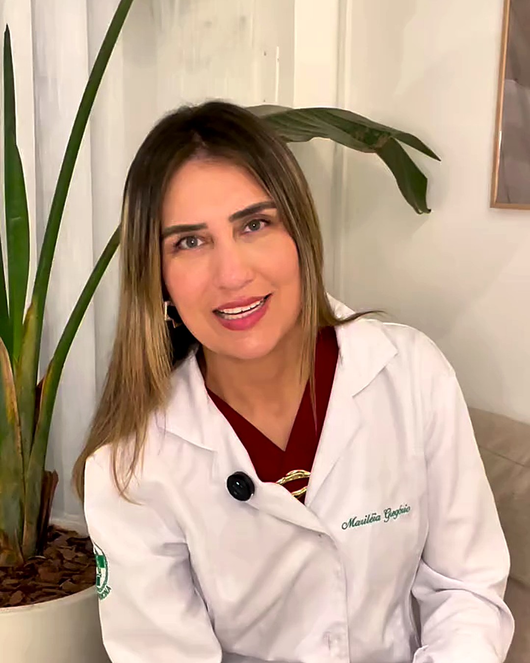 Dra. Mari Gregório, biomédica da NURA, sorrindo, de jaleco